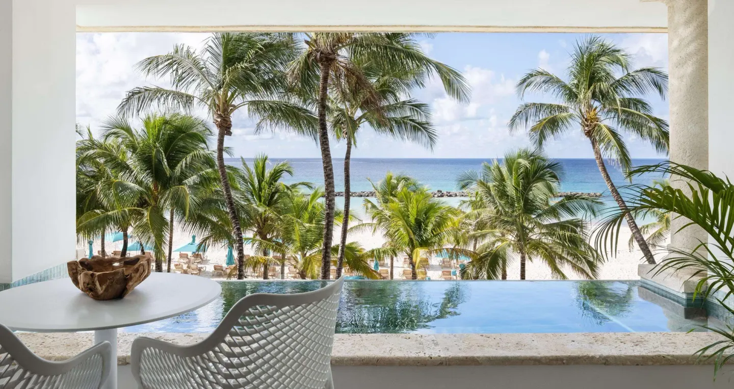 Balcony soaking pool overlooking palms and the beach at Sandals Royal Barbados.