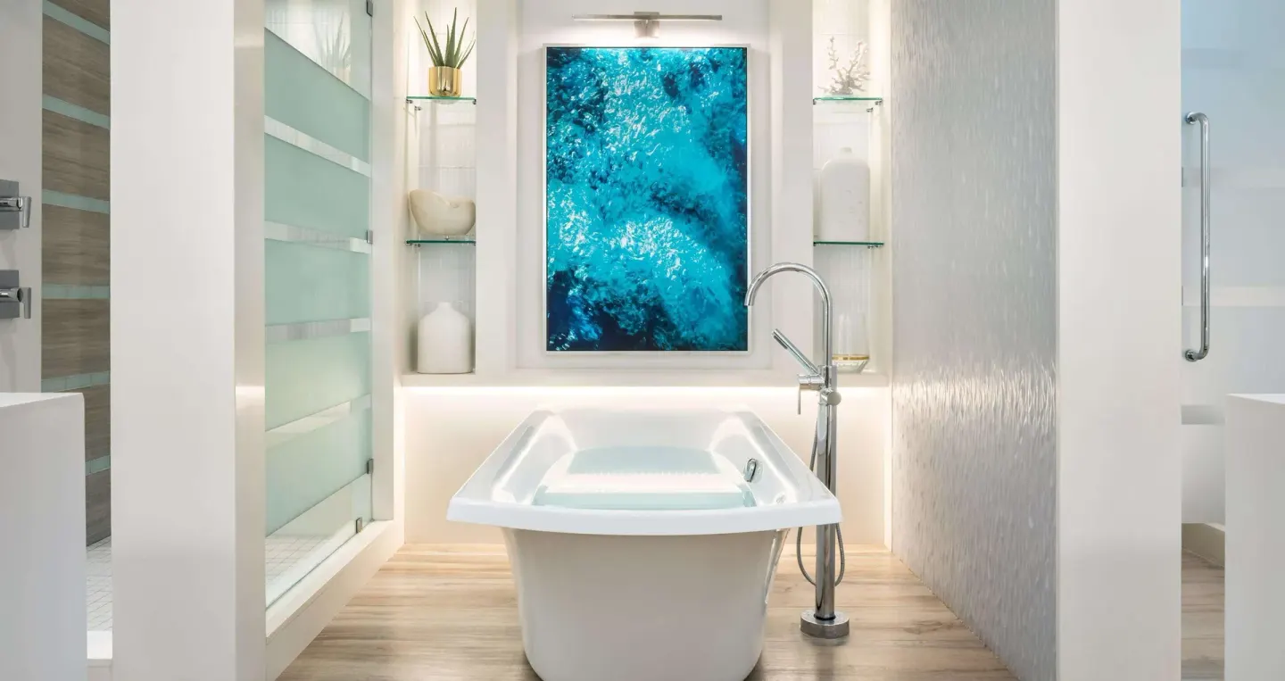 Freestanding bathtub with ocean-inspired wall art at Sandals Royal Barbados.