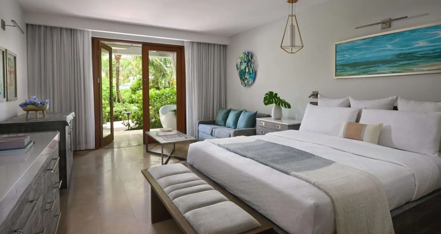 Guest room with king bed and garden-facing doors at Sandals Royal Barbados.