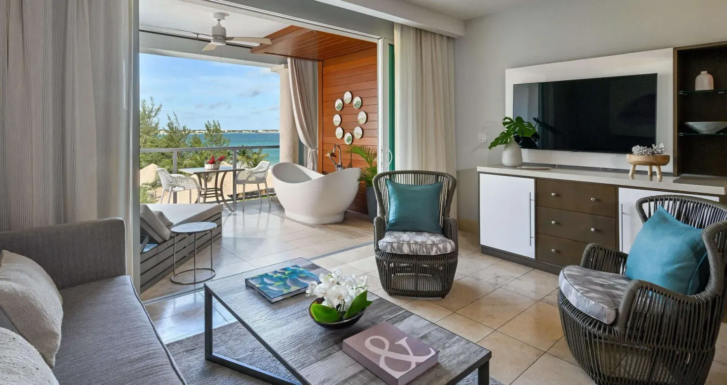 Suite living area with balcony soaking tub and ocean view at Sandals Royal Barbados.