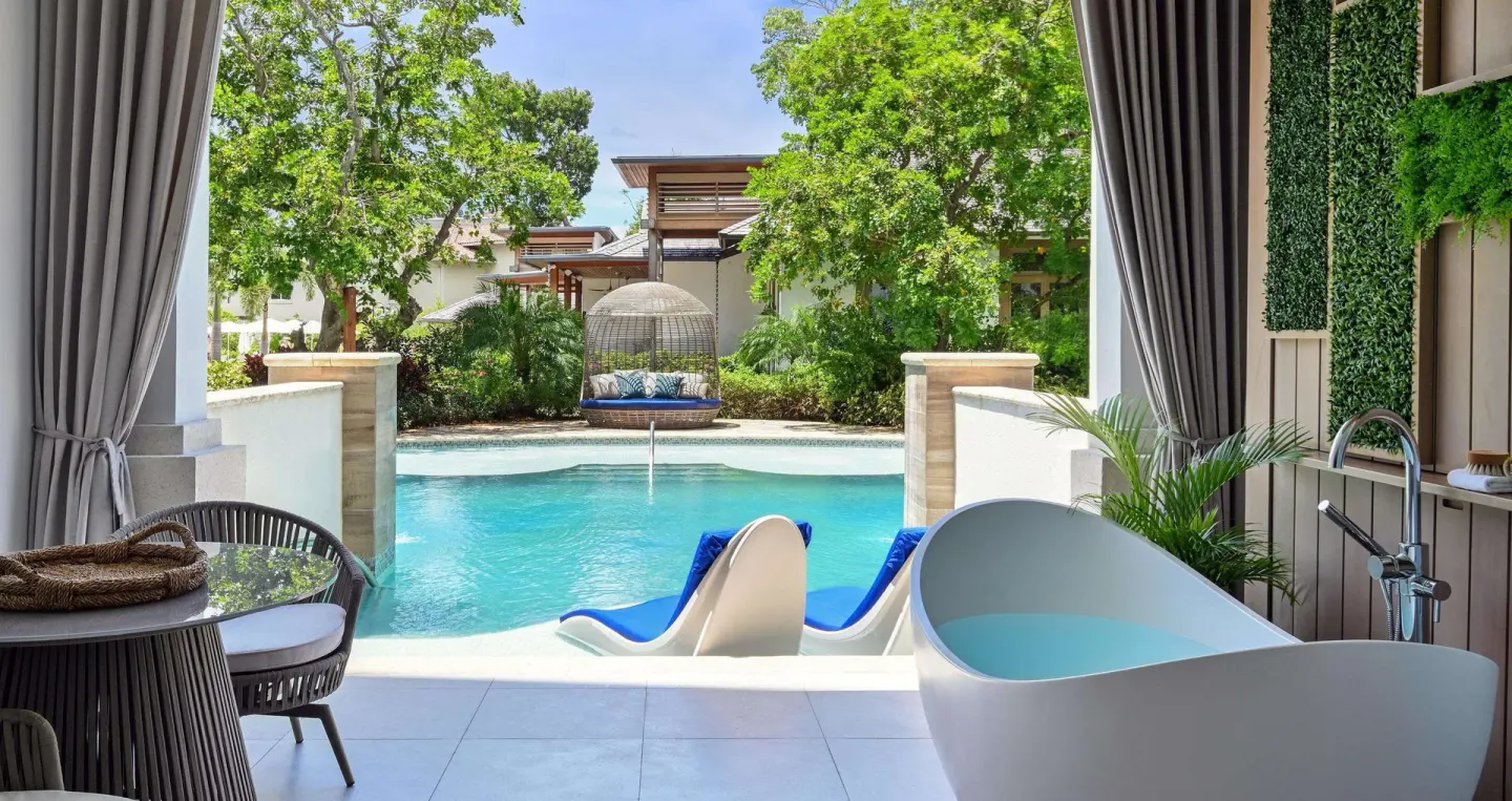 Poolside patio with soaking tub and hanging daybed at Sandals Royal Barbados.