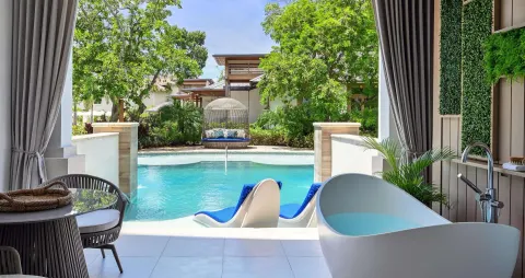 Poolside patio with soaking tub and hanging daybed at Sandals Royal Barbados.
