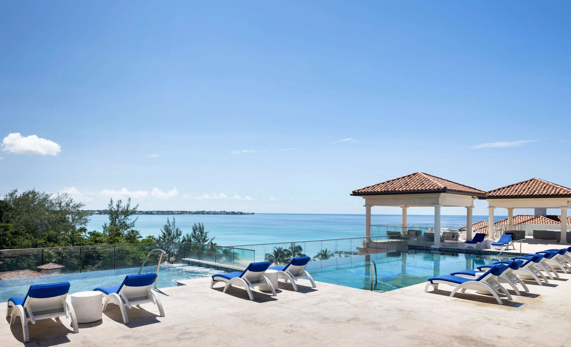 Rooftop infinity pool with ocean views and blue loungers at Sandals Royal Barbados.