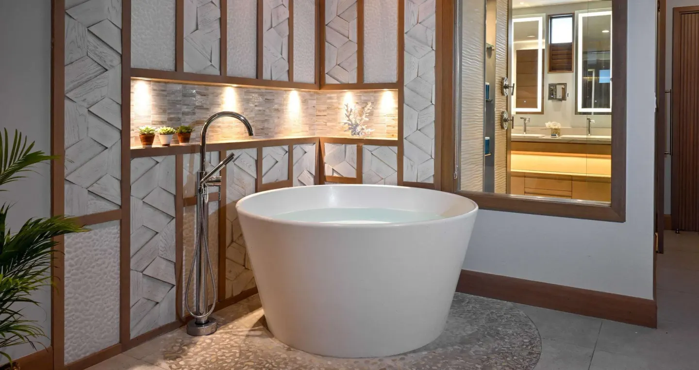 Round soaking tub beside textured wall panels at Sandals Royal Barbados.