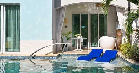 Swim-up patio with blue loungers and soaking tub at Sandals Royal Barbados.