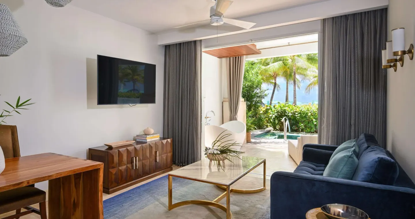 Living room with sofa and patio plunge pool at Sandals Royal Barbados.