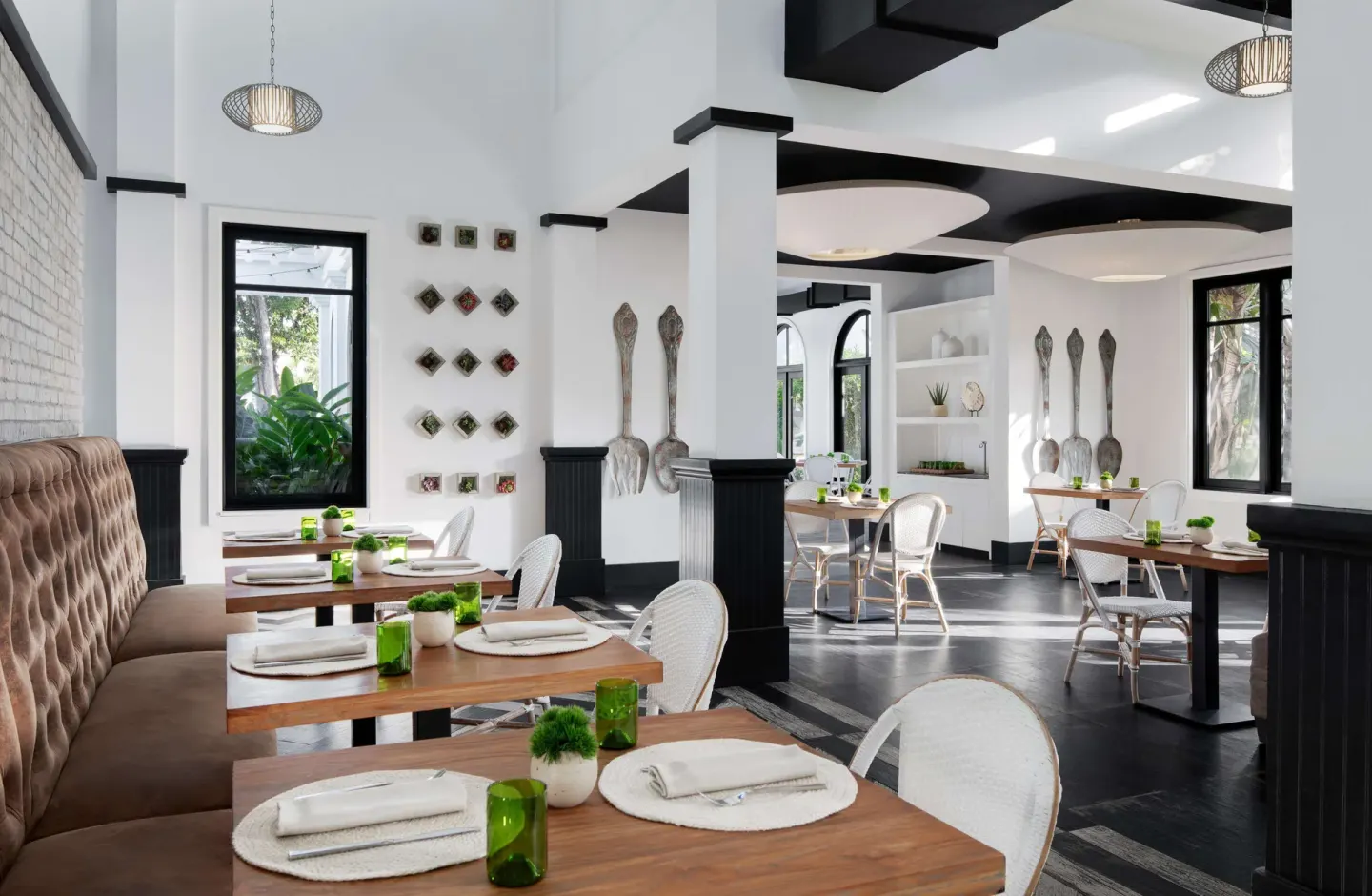 Greenhouse dining room with white walls and green table accents at Sandals Royal Barbados.