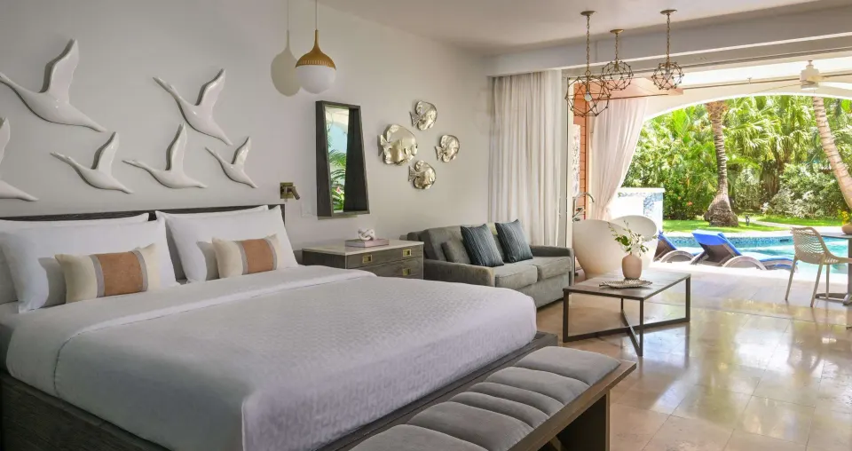 Club Suite bedroom with king bed and pool patio at Sandals Royal Barbados.