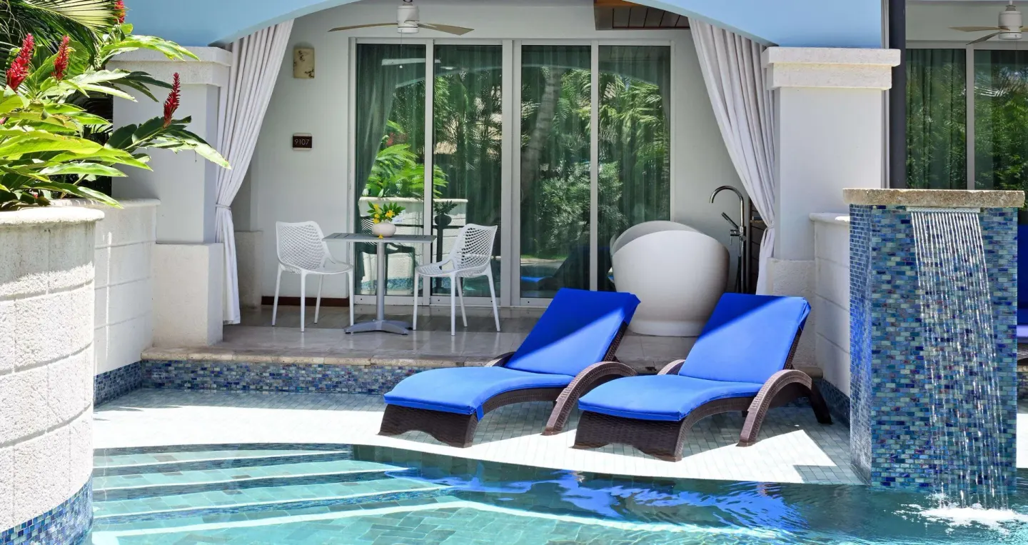 Club Suite swim-up terrace with blue loungers at Sandals Royal Barbados.