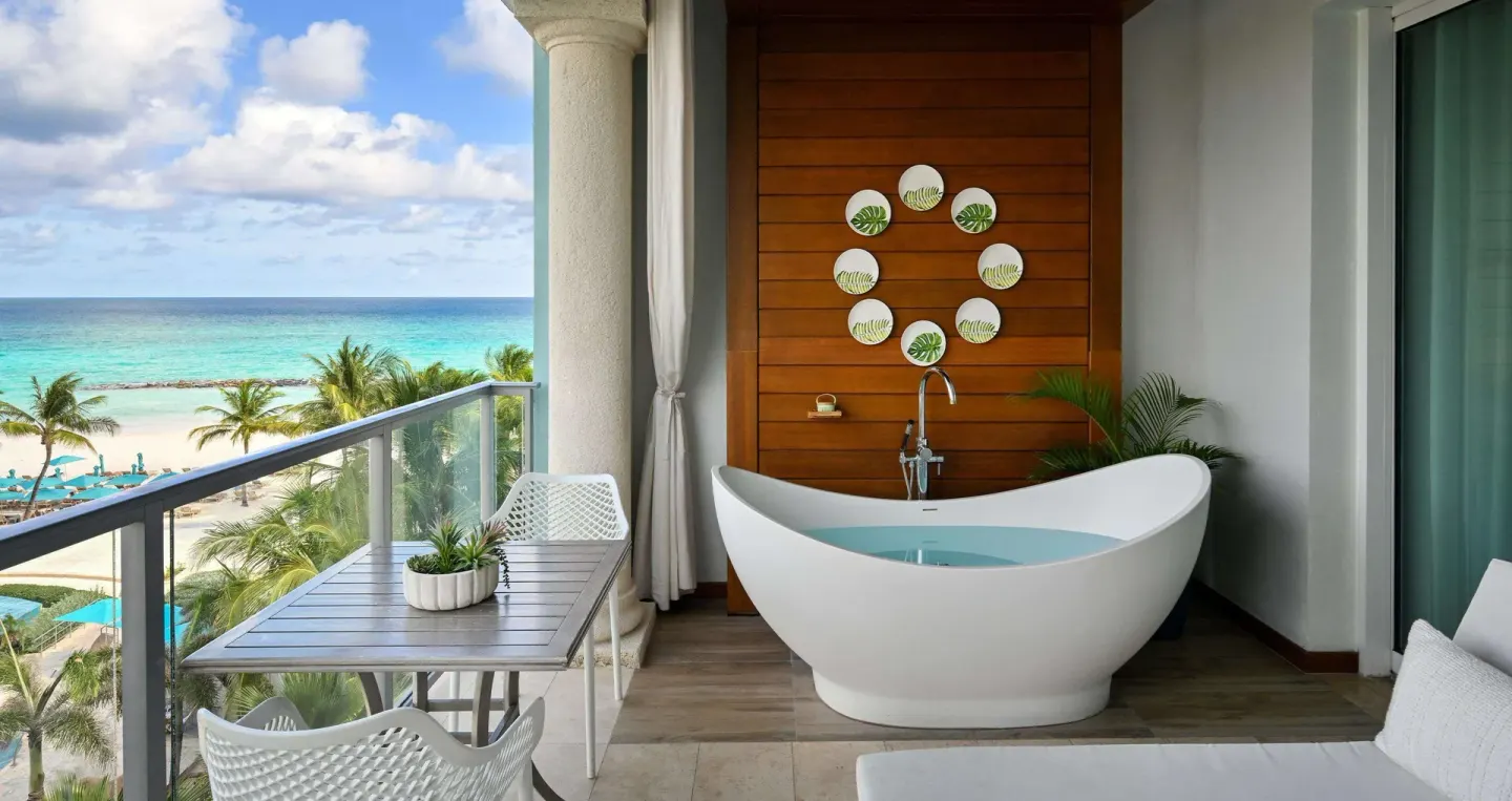Balcony soaking tub with ocean and beach views at Sandals Royal Barbados.