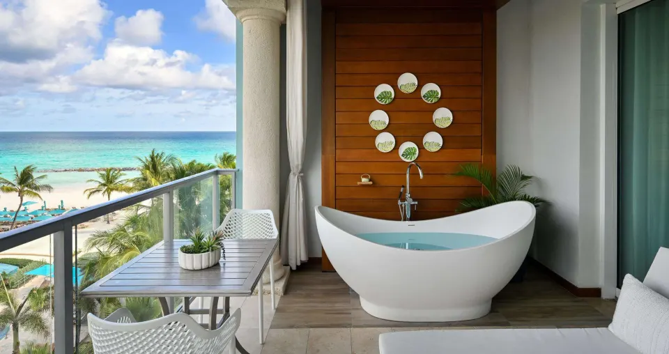 Balcony soaking tub with ocean and beach views at Sandals Royal Barbados.