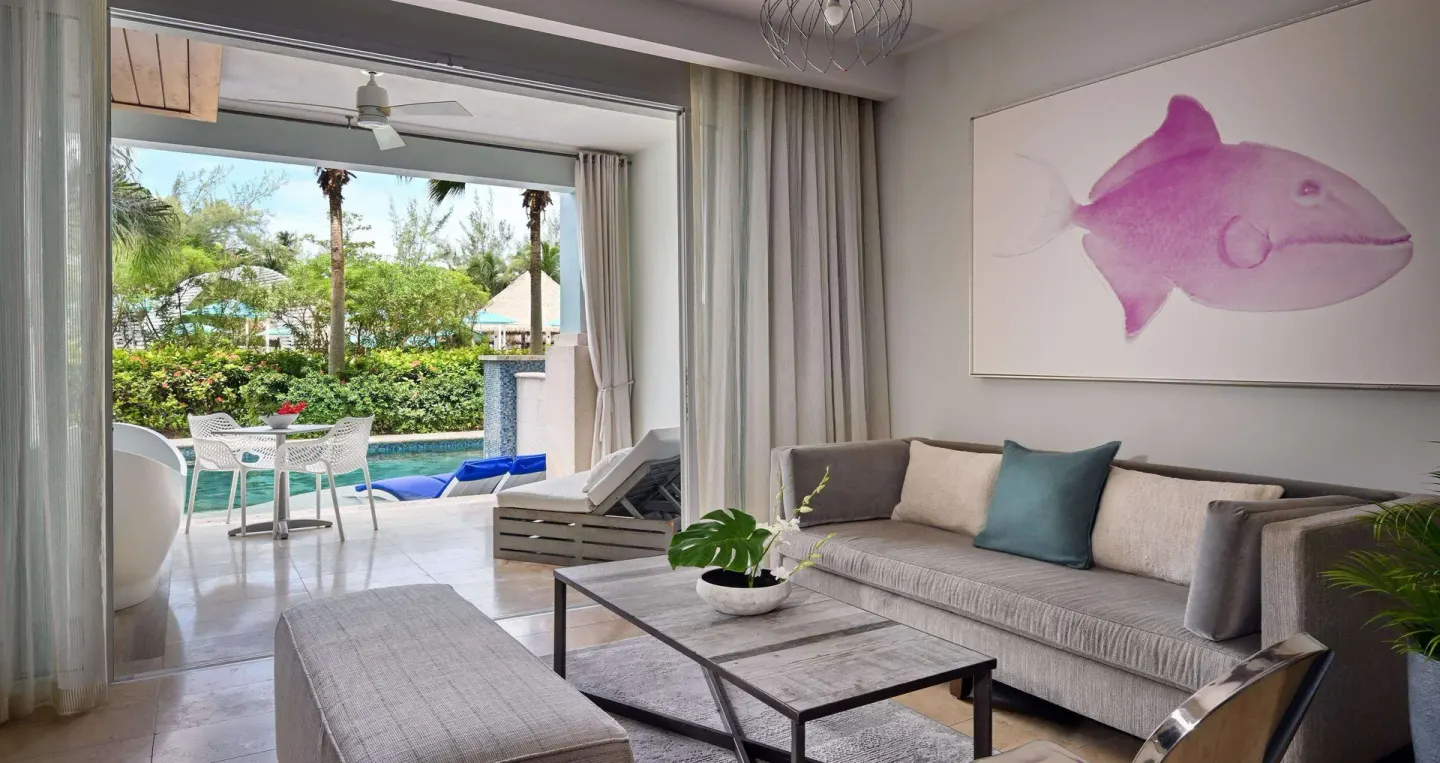 Royal Suite sitting area with sofa, patio, and swim-up pool at Sandals Royal Barbados.