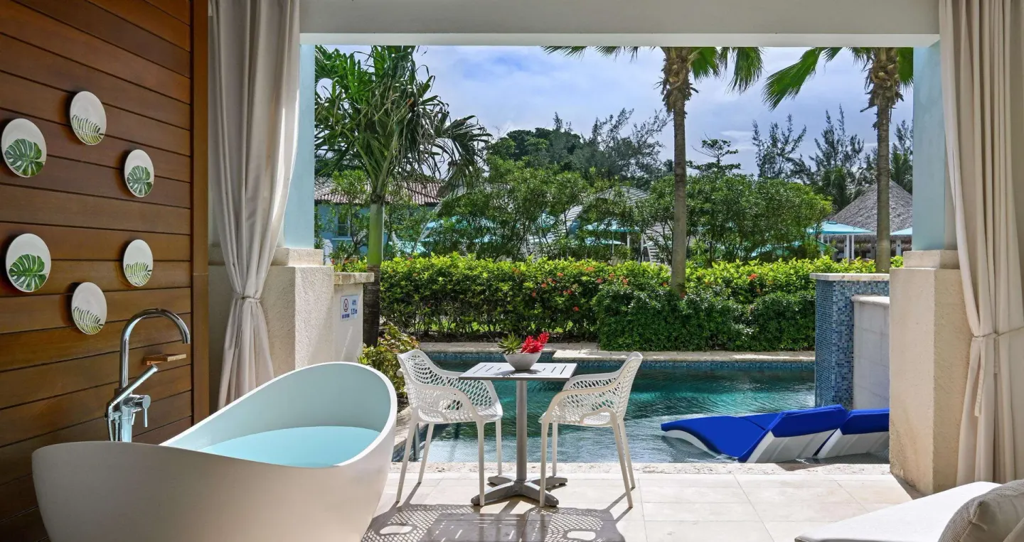 Royal Suite swim-up patio with soaking tub and garden view at Sandals Royal Barbados.