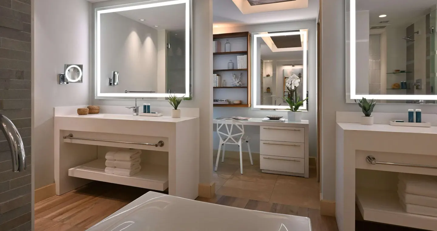 Bathroom vanity area of a one-bedroom balcony suite at Sandals Royal Barbados with lighted mirrors.