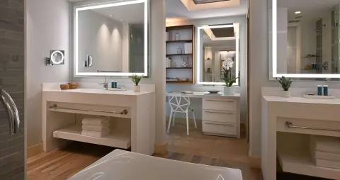 Bathroom vanity area of a one-bedroom balcony suite at Sandals Royal Barbados with lighted mirrors.