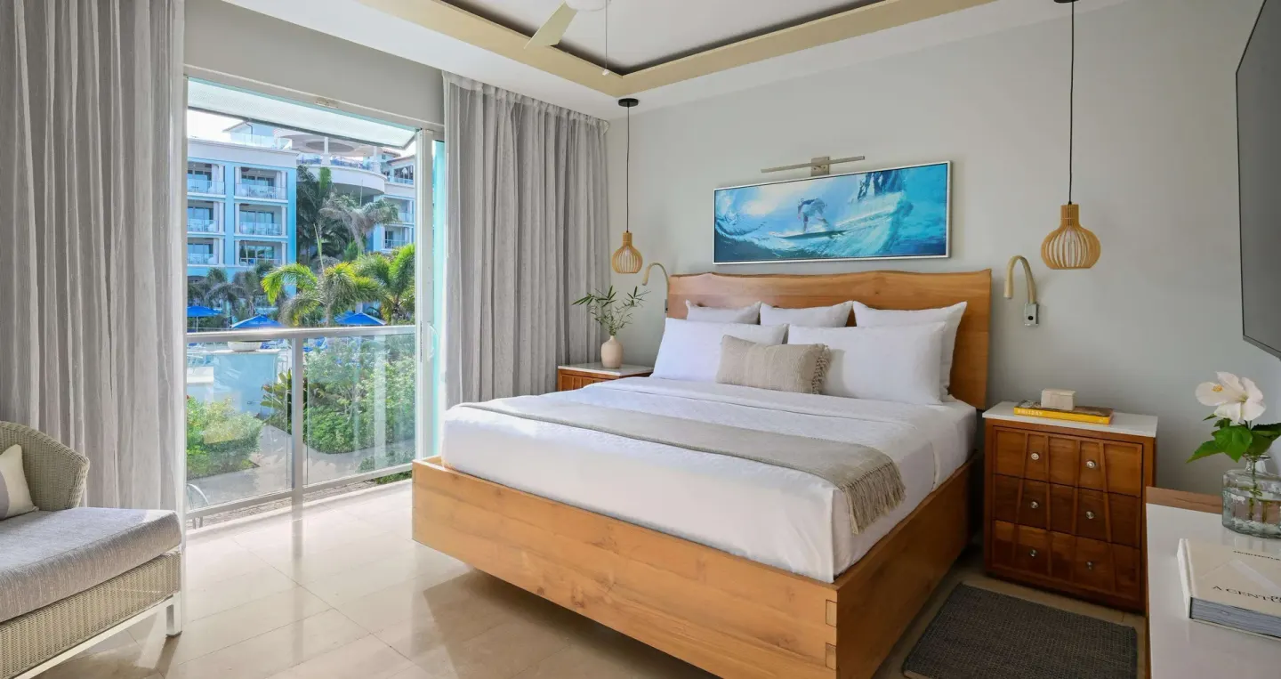 King bedroom in a one-bedroom balcony suite at Sandals Royal Barbados with garden and pool views.