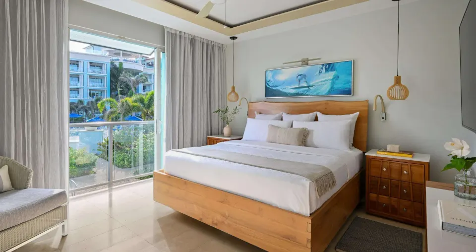 King bedroom in a one-bedroom balcony suite at Sandals Royal Barbados with garden and pool views.