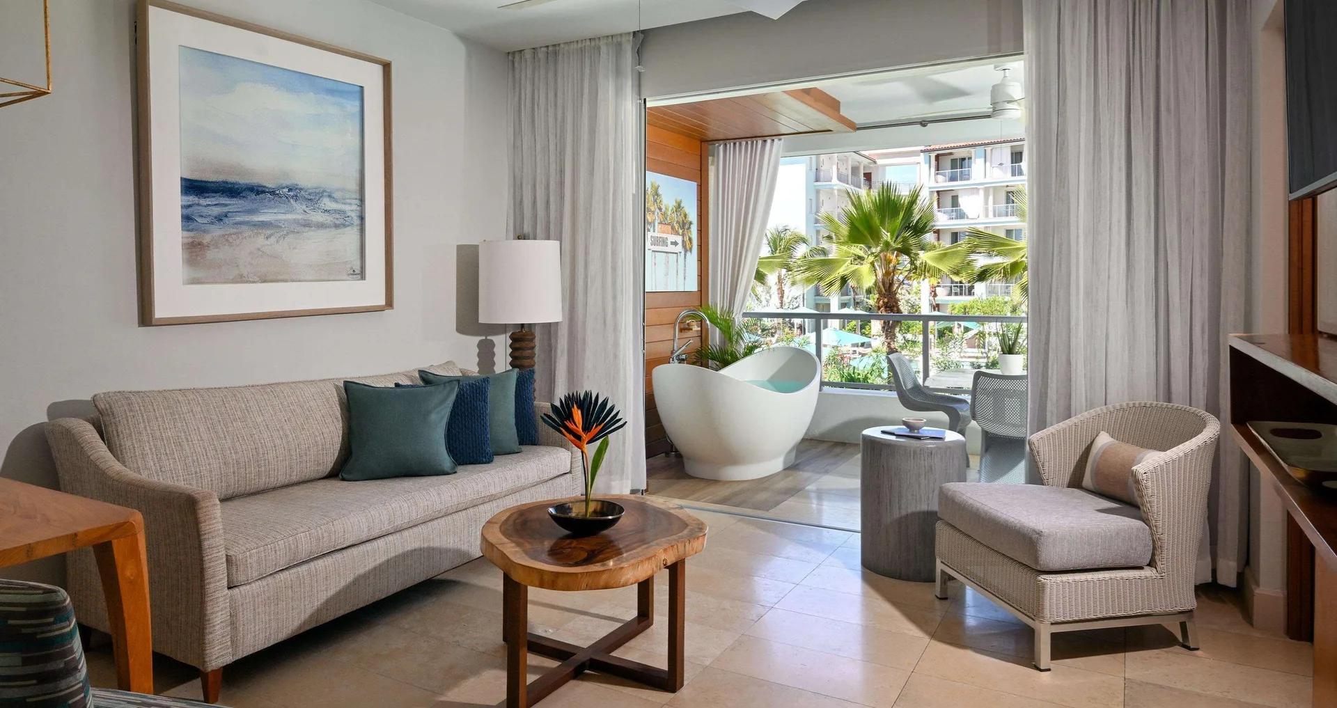 Living area of a one-bedroom balcony suite at Sandals Royal Barbados with sofa and soaking tub.