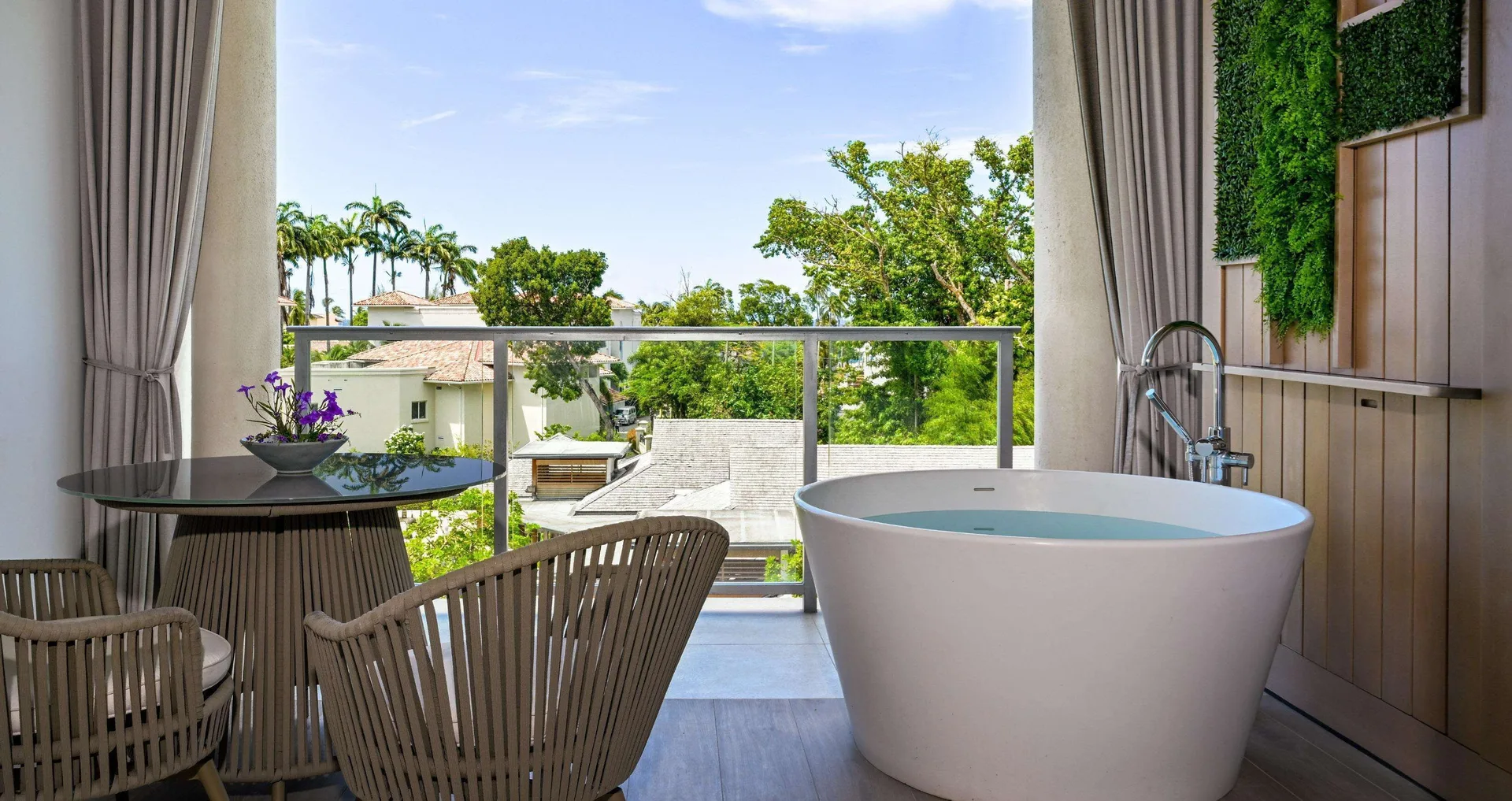 Balcony seating and soaking tub with garden views at Sandals Royal Barbados.