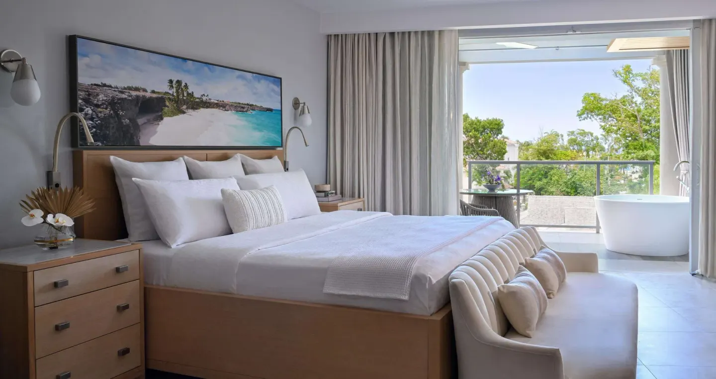 King bed and balcony soaking tub in a suite at Sandals Royal Barbados.