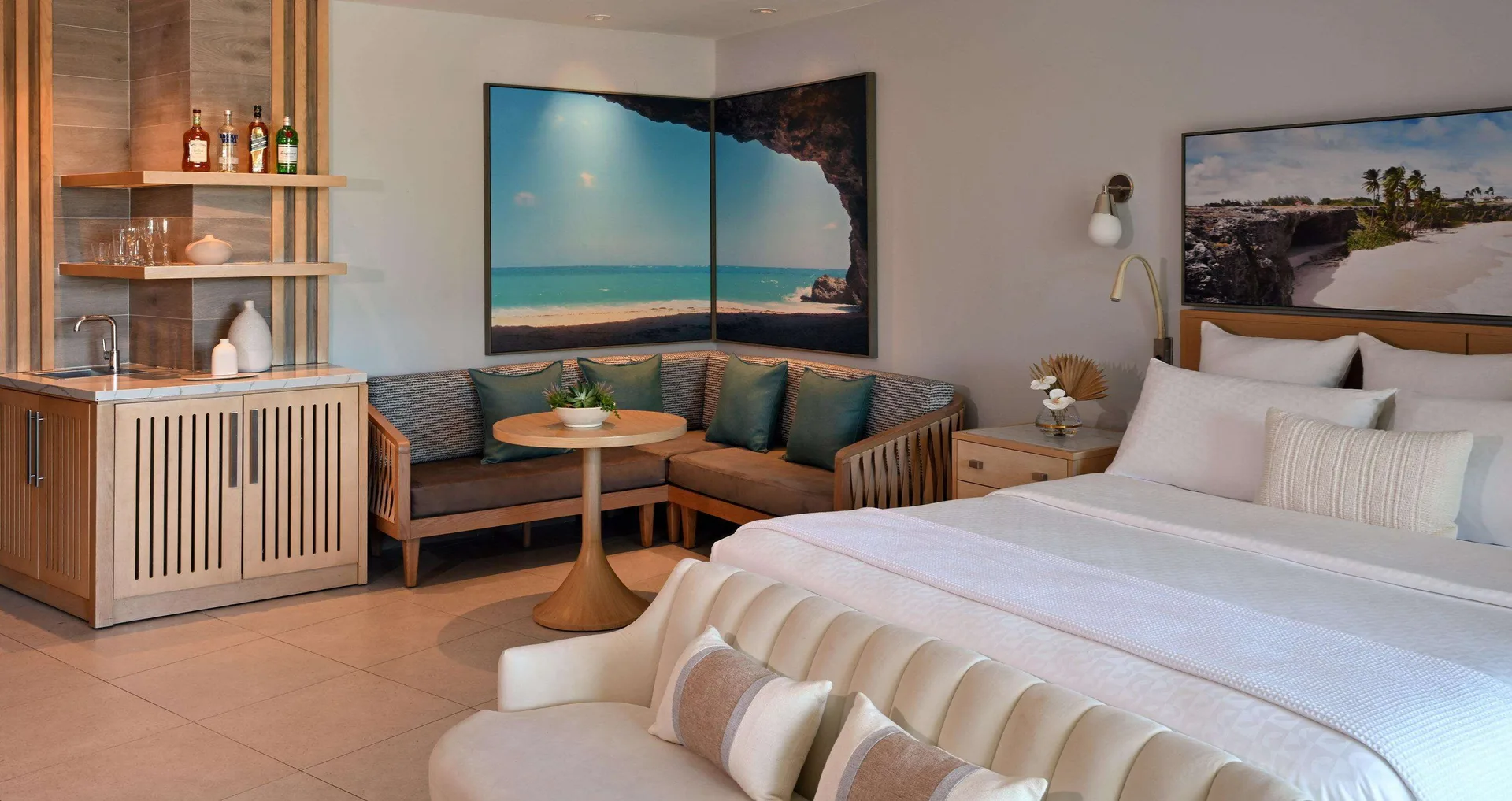 King bed, lounge seating, and wet bar in a suite at Sandals Royal Barbados.