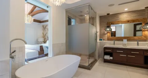 Spacious bathroom with soaking tub and glass shower at Sandals Royal Curacao.