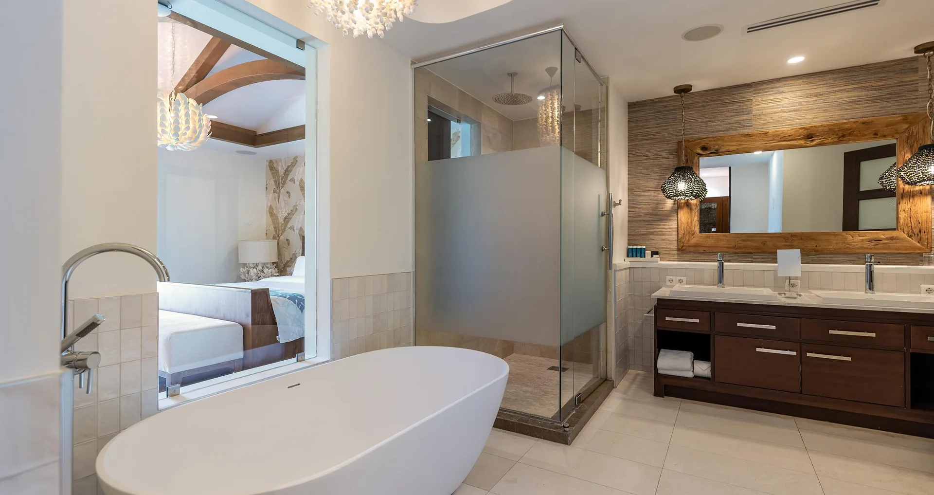 Spacious bathroom with soaking tub and glass shower at Sandals Royal Curacao.