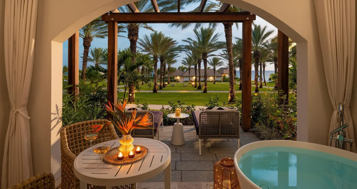 Covered patio with soaking tub and garden seating at Sandals Royal Curacao.