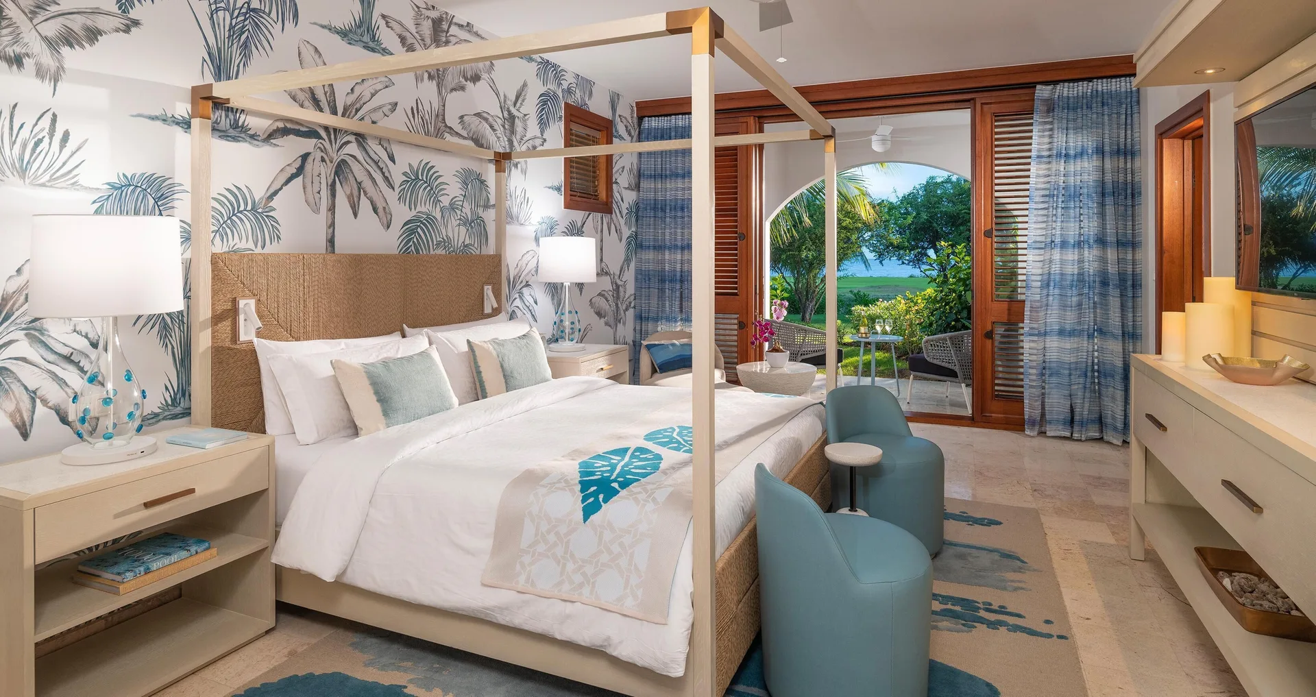 King bedroom with canopy bed and ocean-view balcony at Sandals Royal Curacao.