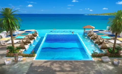 Oceanfront pool with cabanas and turquoise water at Sandals Royal Curacao.