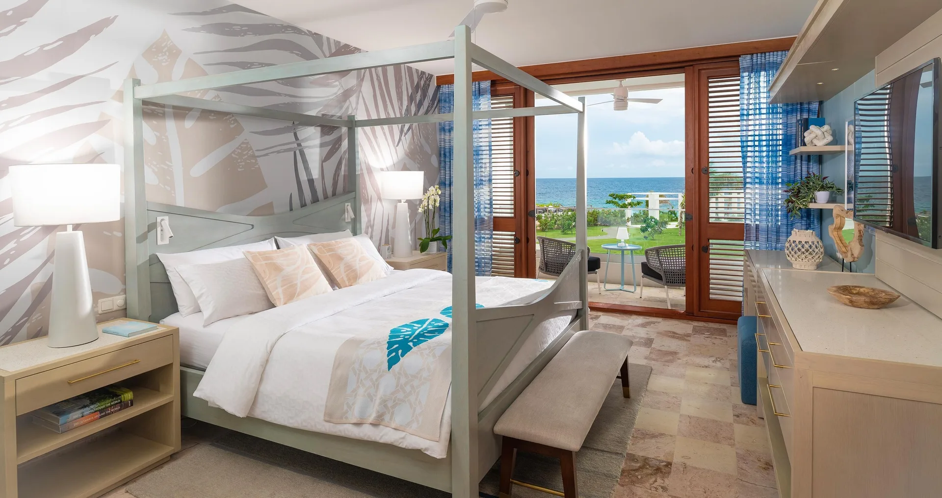 Four-poster king bed with ocean-facing balcony at Sandals Royal Curacao.