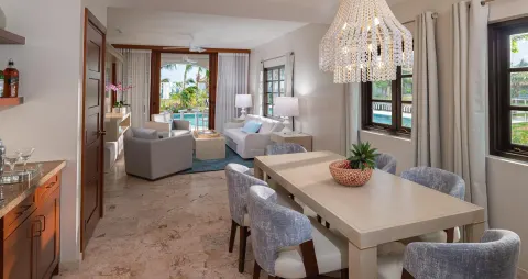 Suite dining and living area with patio doors at Sandals Royal Curacao.