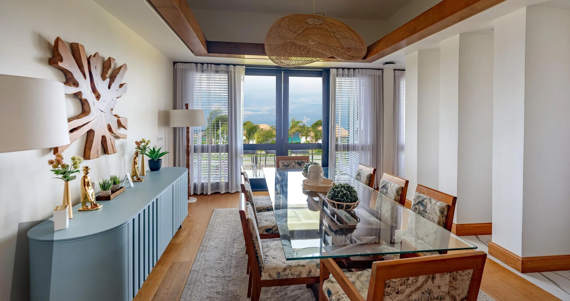 Dining area with glass table and balcony view at Sandals Royal Curacao.