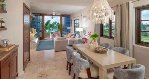 Suite dining and living area with balcony doors at Sandals Royal Curacao.