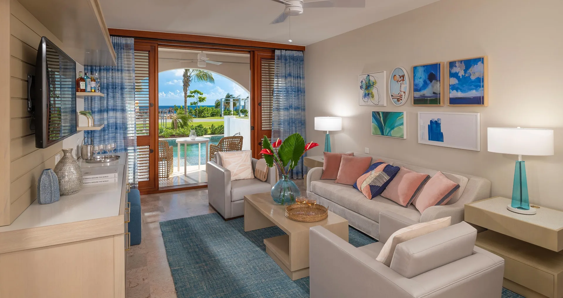 Living room with sofa seating and swim-up terrace view at Sandals Royal Curacao.