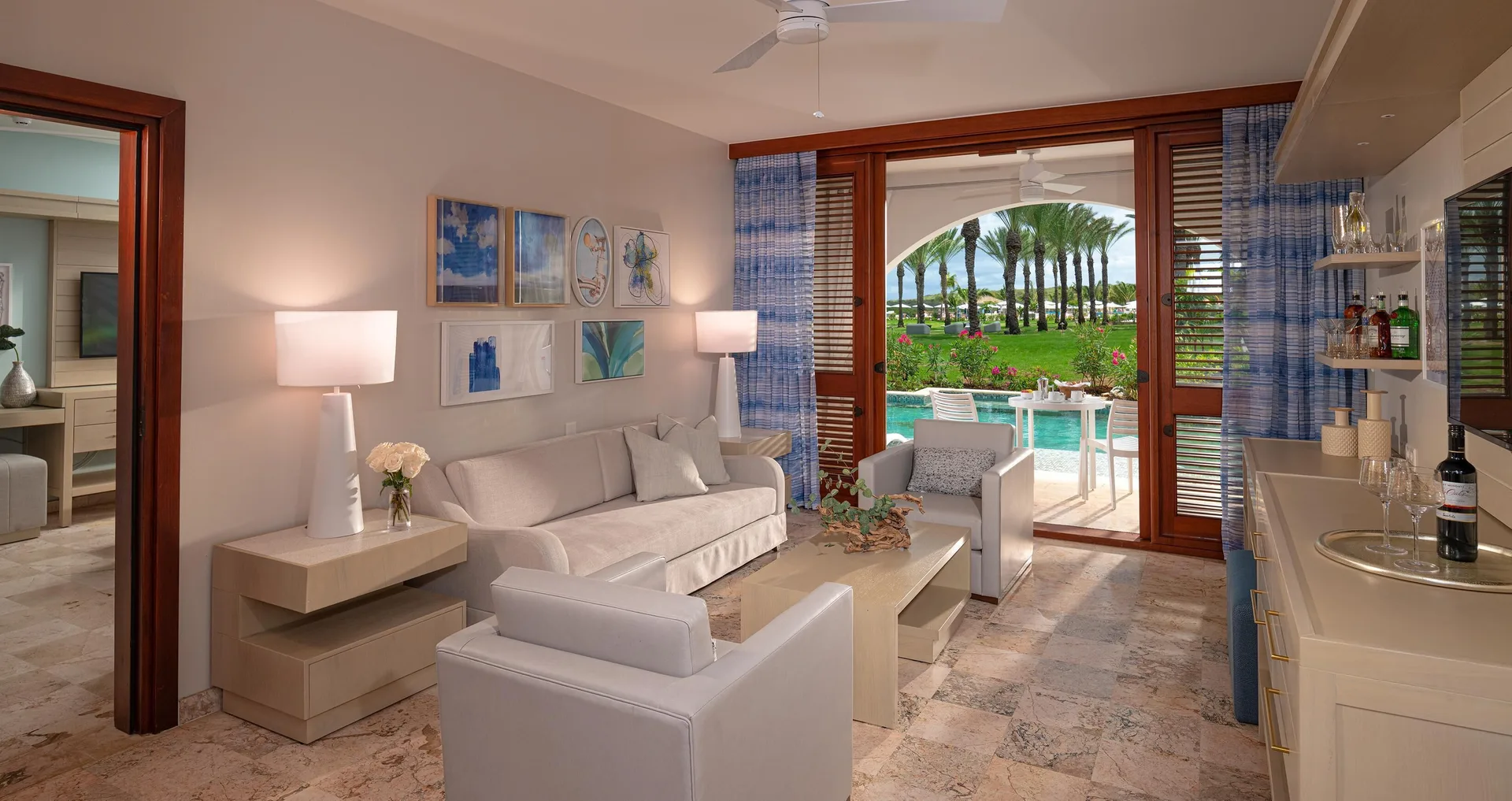 Suite lounge with sofa, bar area, and swim-up patio at Sandals Royal Curacao.