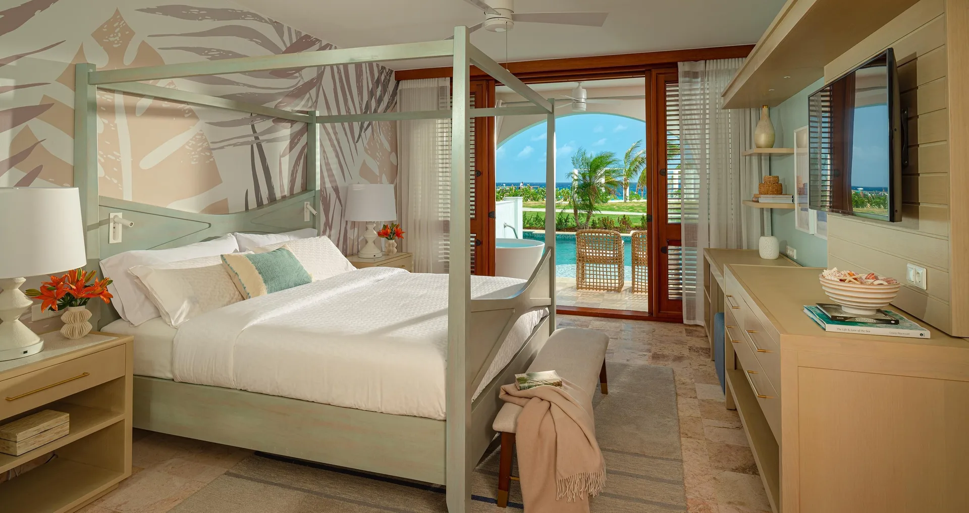 Guest room with canopy king bed and swim-up terrace at Sandals Royal Curacao.