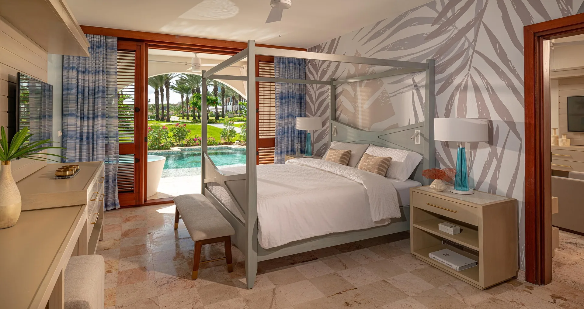 Four-poster king bedroom opening to a swim-up pool at Sandals Royal Curacao.
