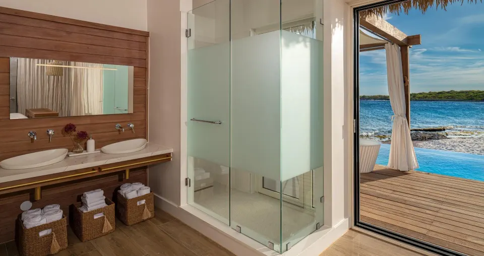 Awa Seaside Butler Bungalow bathroom with double vanity and ocean view at Sandals Royal Curacao.