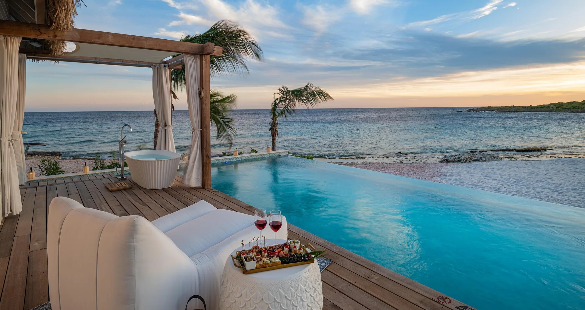Awa Seaside Butler Bungalow deck with private pool at sunset at Sandals Royal Curacao.