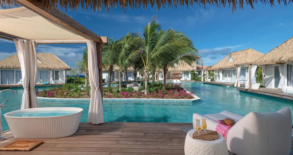 Patio soaking tub and pool view at a bungalow at Sandals Royal Curacao.