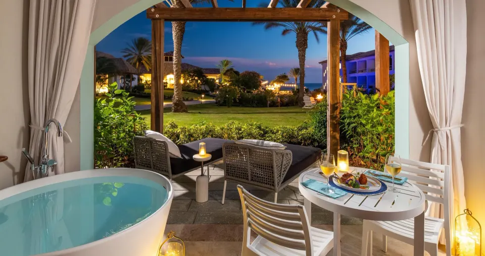Patio soaking tub and outdoor seating for a Subi walkout room at Sandals Royal Curacao.
