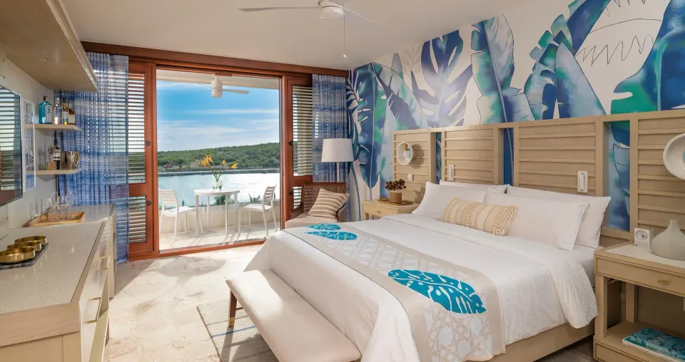 Sunchi Luxury Beachfront king bed and balcony view at Sandals Royal Curacao.