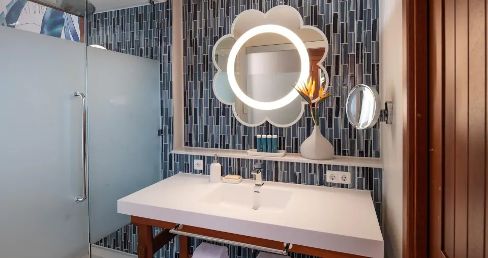 Bathroom sink and lighted mirror in a Sunchi suite at Sandals Royal Curacao.