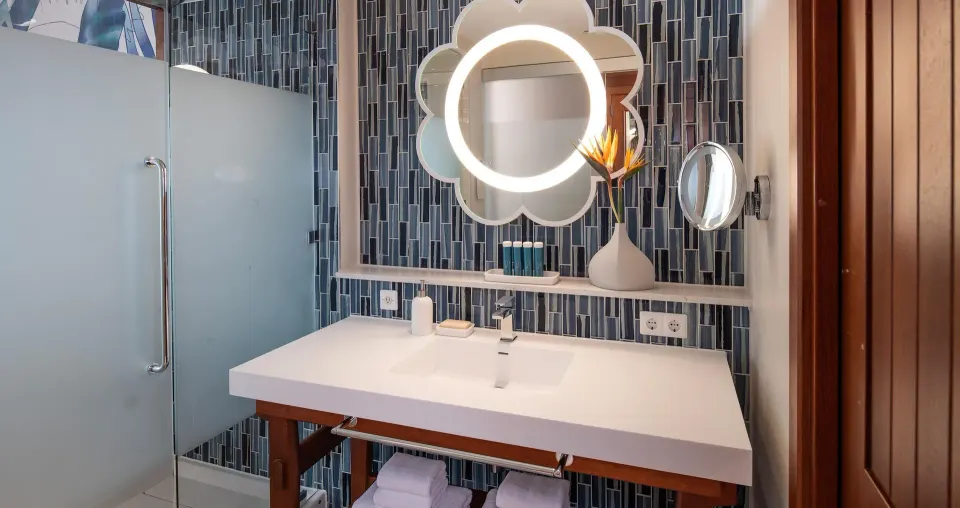 Sunchi suite bathroom at Sandals Royal Curacao with vanity, towels, and glass shower.
