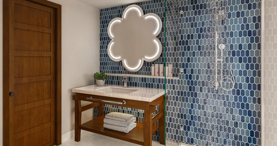 Blue-tiled bathroom vanity and glass shower in a Sunchi suite at Sandals Royal Curacao.