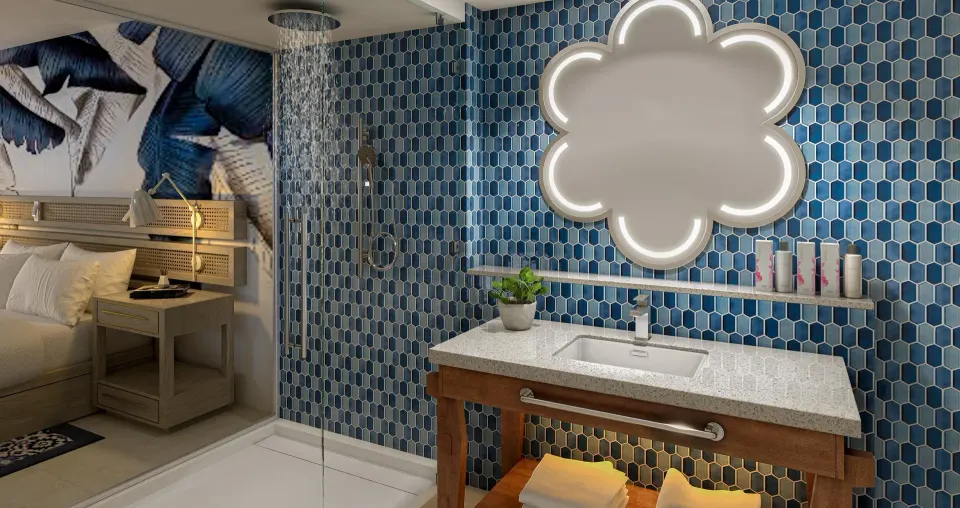 Blue-tiled bathroom vanity and shower beside a junior suite bedroom at Sandals Royal Curacao.