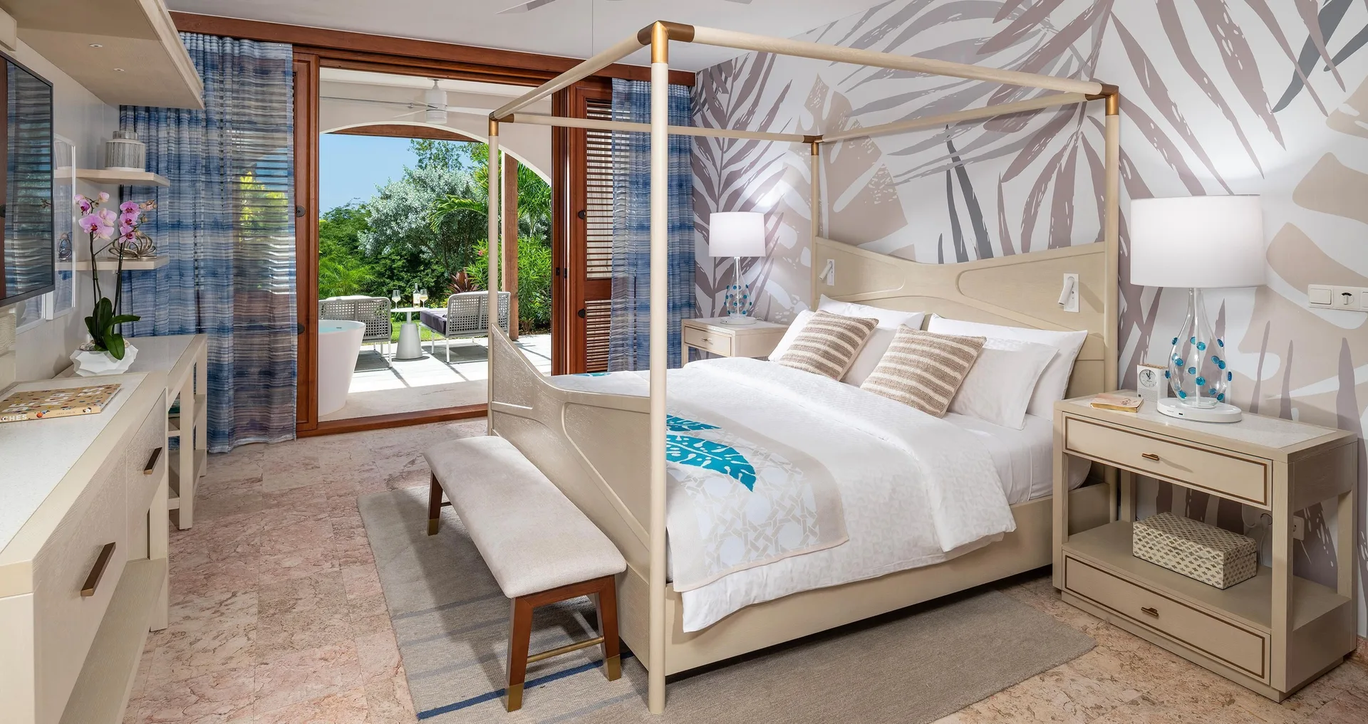 King bed and patio doors in a Sunchi beachfront room at Sandals Royal Curacao.