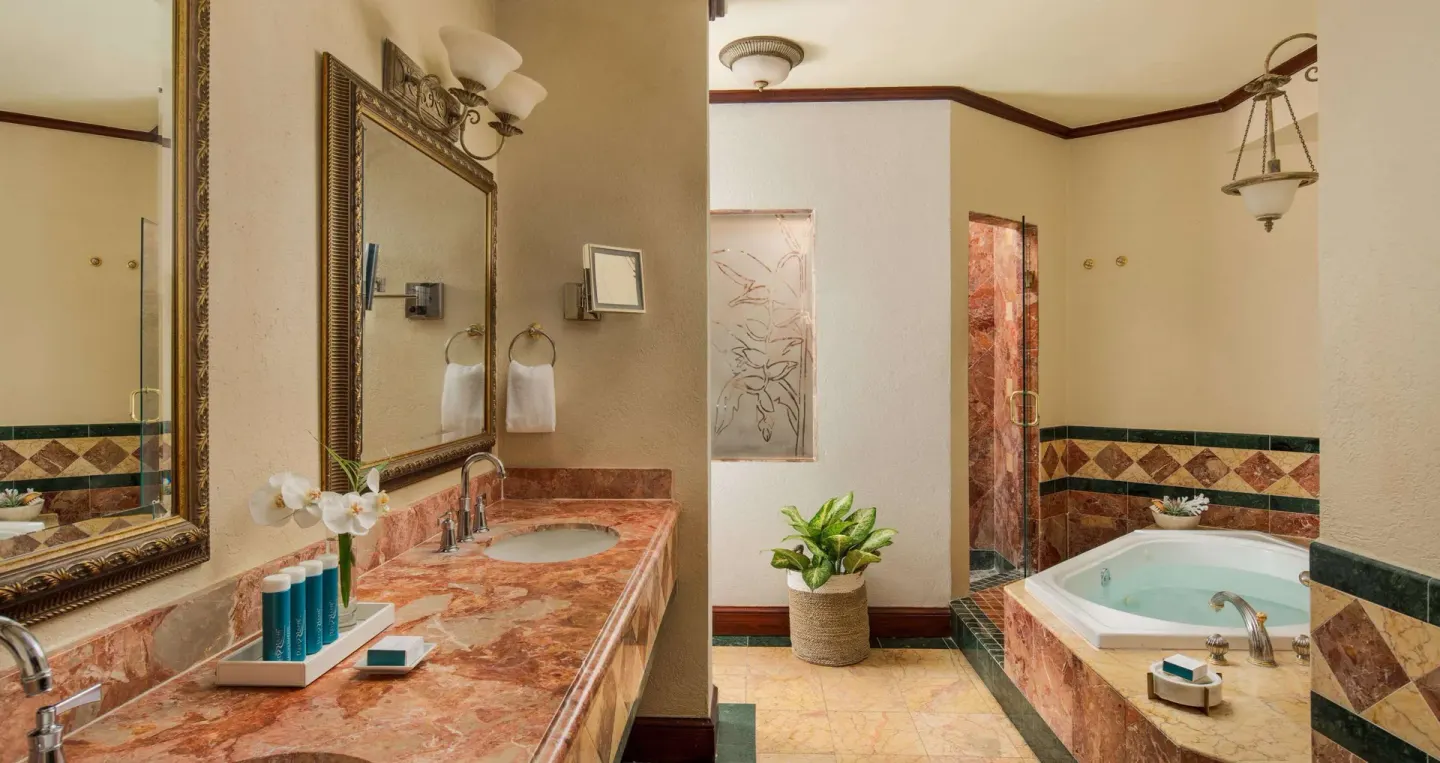 Bathroom vanity and soaking tub with patterned tile at Sandals Royal Plantation.