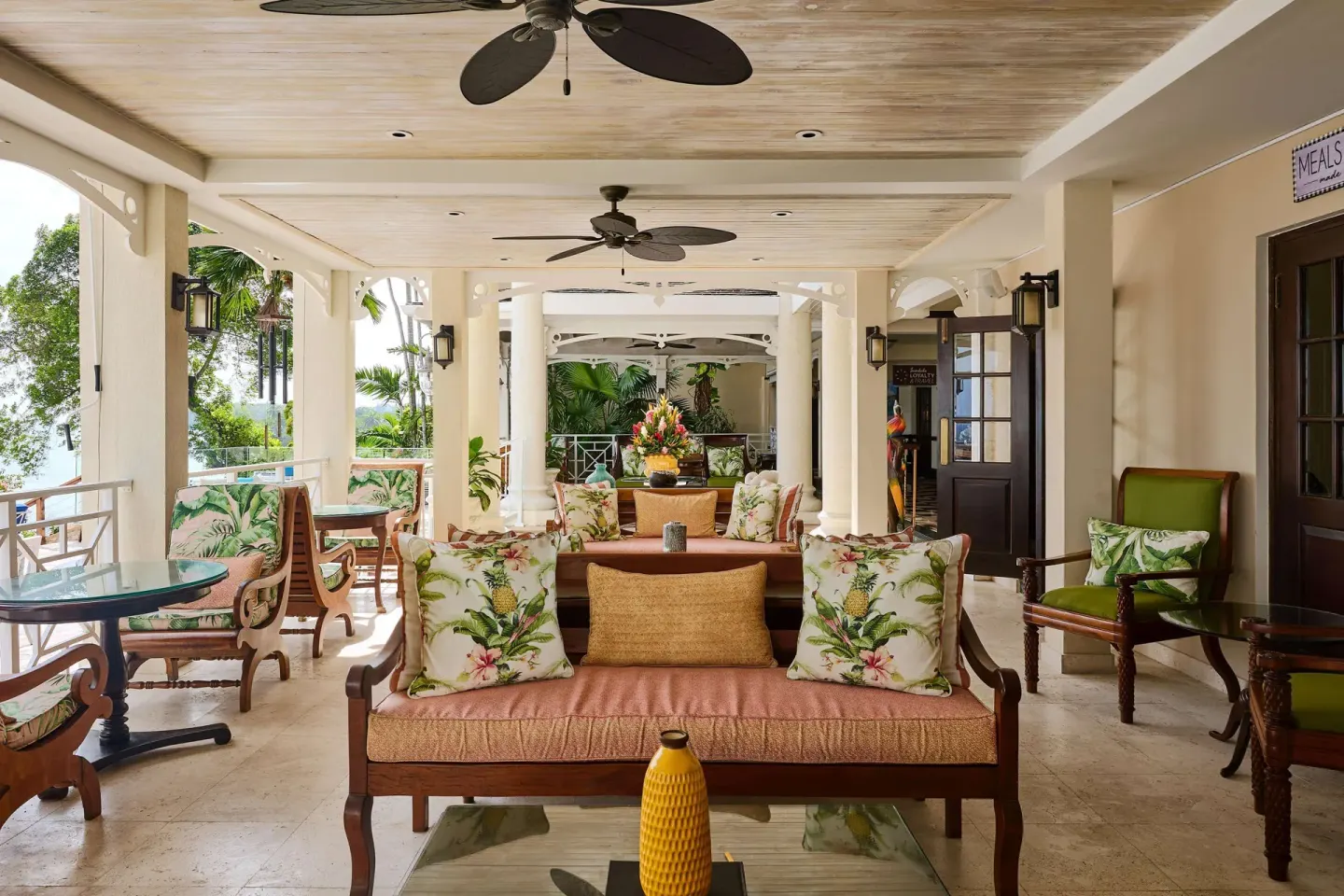 Covered lounge terrace with tropical cushions at Sandals Royal Plantation.